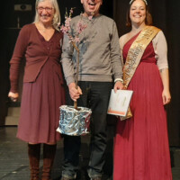 Günther Schomber, wurde für seine langjährige außergewöhnliche aktive Vereinsarbeit mit einem Pfirsichbaum geehrt. Links: Margret Göhmann, 1.Vorsitzende des Bienenzuchtverein Lumbdatal, rechts: Honigkönigin Kathrin I.